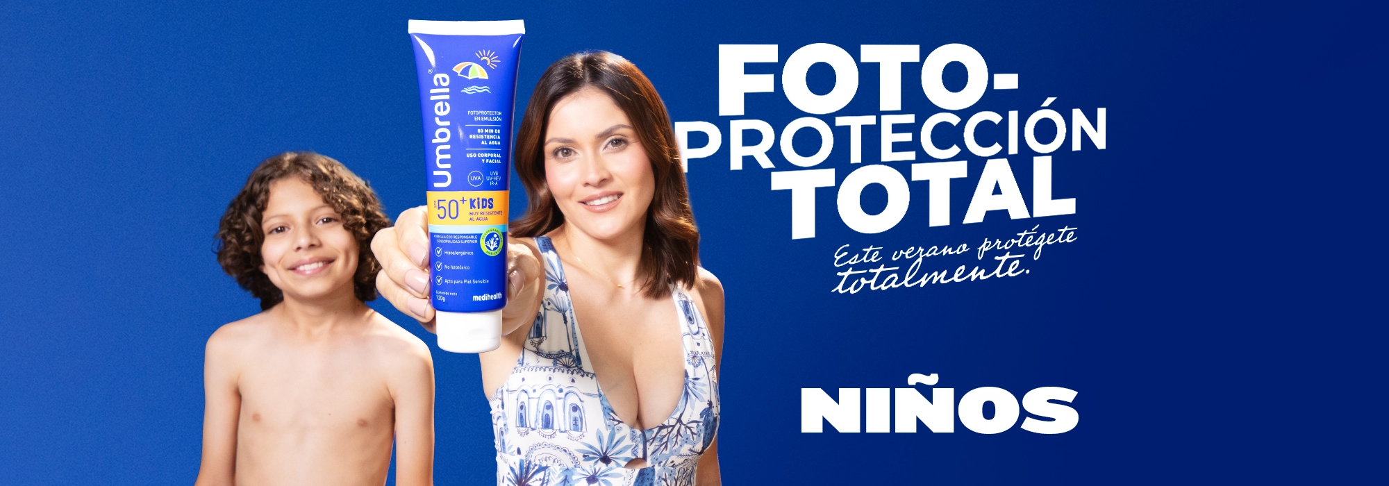 Mujer y niño sonrientes sostienen protector solar Umbrella Kids Muy Resistente al Agua SPF 50+, sobre fondo azul con el mensaje ‘Fotoprotección total. Este verano protégente totalmente. Niños’.